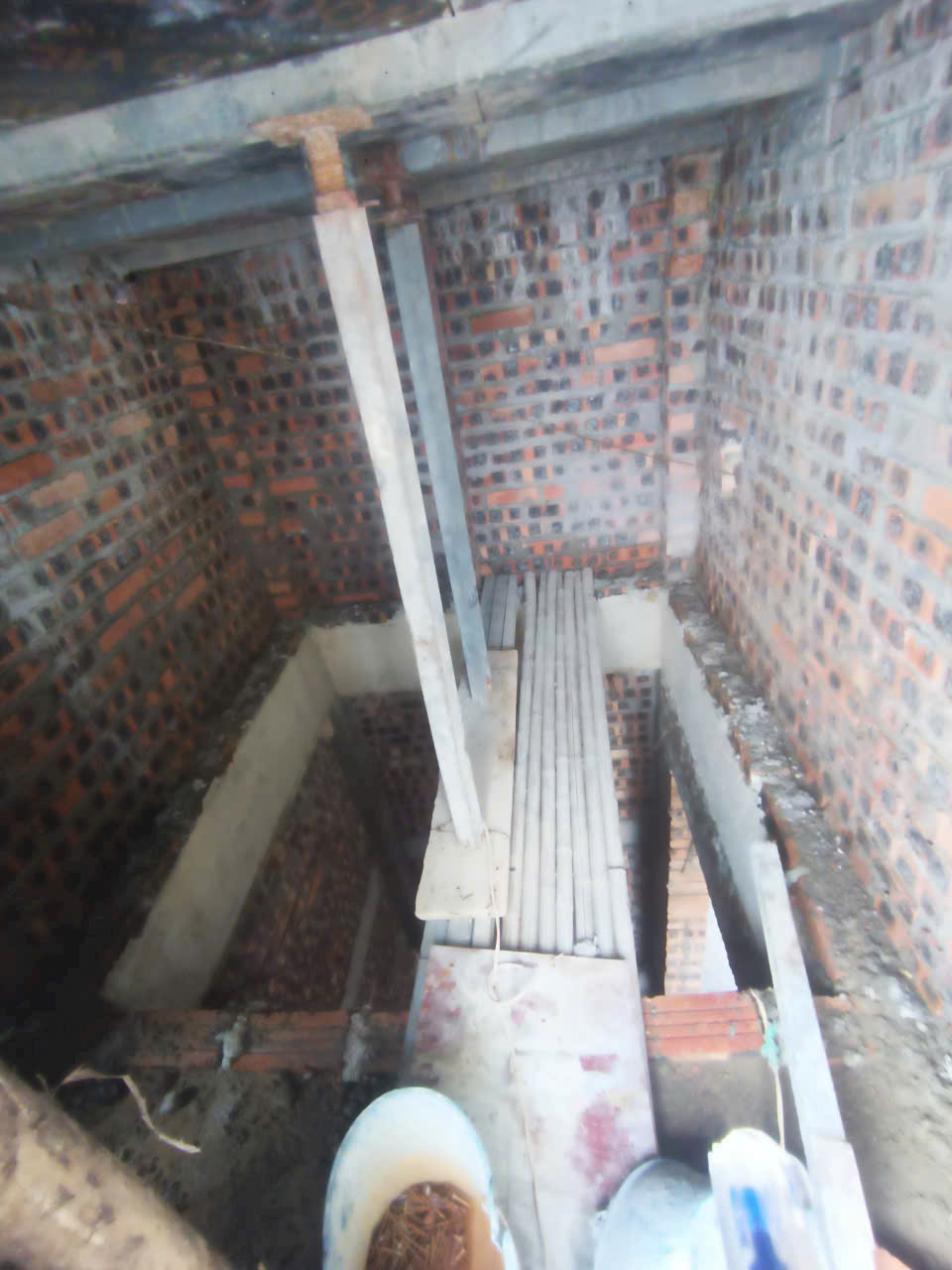 Giàn giáo và ván gỗ thi công sàn bê tông trong nhà xây tường gạch đỏ